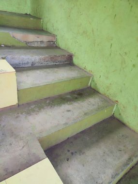 Dışarıdaki yeşil taş duvarda taş merdivenler.