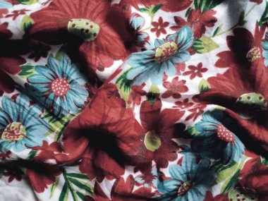 Temel kumaş beyaz, kırmızı ve mavi çiçek motifleri ve yaprakları var.