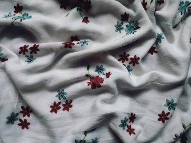 Temel kumaş beyaz, kırmızı ve mavi çiçek motifleri ve yaprakları var.