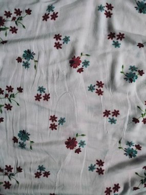 Temel kumaş beyaz, kırmızı ve mavi çiçek motifleri ve yaprakları var.