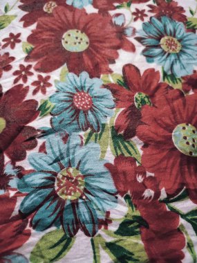 Temel kumaş beyaz, kırmızı ve mavi çiçek motifleri ve yaprakları var.