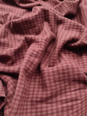 Kumaşın arka planı ve şablonu pürüzsüz bir kırmızı kareli maddedir.