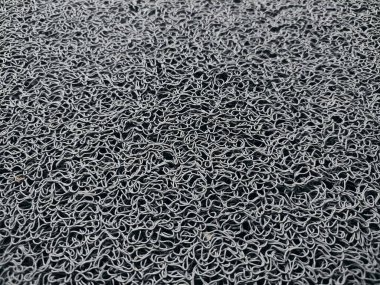 Genellikle kapının önüne konan gri bir hoş geldin paspası.