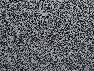 Genellikle kapının önüne konan gri bir hoş geldin paspası.