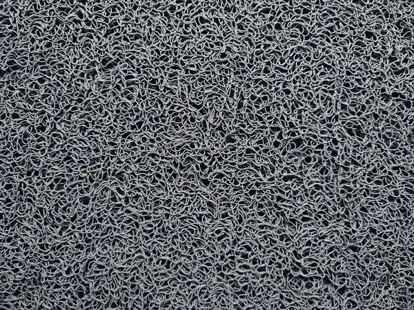 Genellikle kapının önüne konan gri bir hoş geldin paspası.