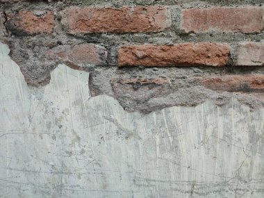 Yıpranmış ve kısmen yok edilmiş eski bir tuğla duvarın parçası.