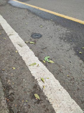 Sürücü güvenliği için asfalt yol yüzeyindeki beyaz ve sarı çizgiler