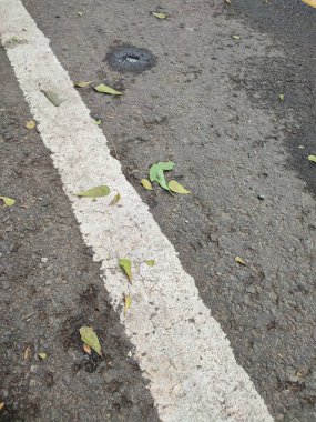 Sürücü güvenliği için asfalt yol yüzeyindeki beyaz çizgiler