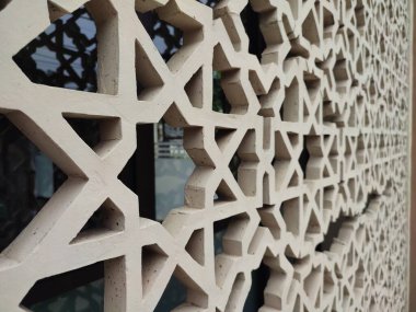 Parlak renkler ve simetrik desenler içeren detaylı bir İslami geometrik mozaik. Tasarım geleneksel arabesk motiflerini içerir.