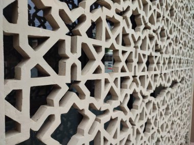 Parlak renkler ve simetrik desenler içeren detaylı bir İslami geometrik mozaik. Tasarım geleneksel arabesk motiflerini içerir.