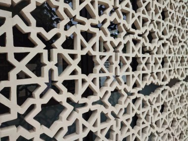 Parlak renkler ve simetrik desenler içeren detaylı bir İslami geometrik mozaik. Tasarım geleneksel arabesk motiflerini içerir.