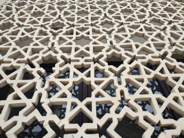 Parlak renkler ve simetrik desenler içeren detaylı bir İslami geometrik mozaik. Tasarım geleneksel arabesk motiflerini içerir.