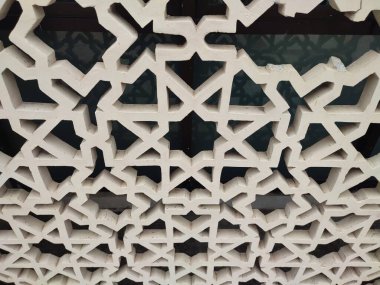 Parlak renkler ve simetrik desenler içeren detaylı bir İslami geometrik mozaik. Tasarım geleneksel arabesk motiflerini içerir.