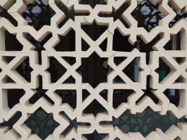 Parlak renkler ve simetrik desenler içeren detaylı bir İslami geometrik mozaik. Tasarım geleneksel arabesk motiflerini içerir.