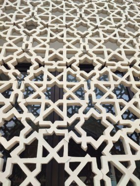 Parlak renkler ve simetrik desenler içeren detaylı bir İslami geometrik mozaik. Tasarım geleneksel arabesk motiflerini içerir.