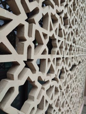 Parlak renkler ve simetrik desenler içeren detaylı bir İslami geometrik mozaik. Tasarım geleneksel arabesk motiflerini içerir.