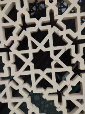 Parlak renkler ve simetrik desenler içeren detaylı bir İslami geometrik mozaik. Tasarım geleneksel arabesk motiflerini içerir.