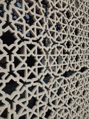 Parlak renkler ve simetrik desenler içeren detaylı bir İslami geometrik mozaik. Tasarım geleneksel arabesk motiflerini içerir.