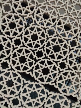 Parlak renkler ve simetrik desenler içeren detaylı bir İslami geometrik mozaik. Tasarım geleneksel arabesk motiflerini içerir.