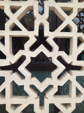 Parlak renkler ve simetrik desenler içeren detaylı bir İslami geometrik mozaik. Tasarım geleneksel arabesk motiflerini içerir.