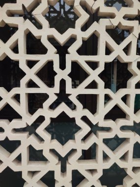 Parlak renkler ve simetrik desenler içeren detaylı bir İslami geometrik mozaik. Tasarım geleneksel arabesk motiflerini içerir.