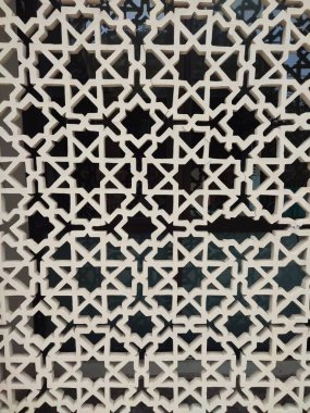 Parlak renkler ve simetrik desenler içeren detaylı bir İslami geometrik mozaik. Tasarım geleneksel arabesk motiflerini içerir.