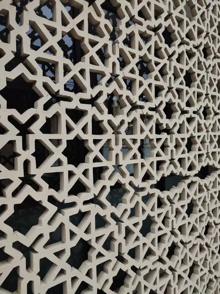 Parlak renkler ve simetrik desenler içeren detaylı bir İslami geometrik mozaik. Tasarım geleneksel arabesk motiflerini içerir.