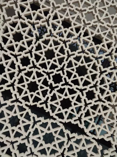 Parlak renkler ve simetrik desenler içeren detaylı bir İslami geometrik mozaik. Tasarım geleneksel arabesk motiflerini içerir.