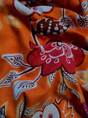 Çiçek, dal ve turuncu arka planlı yaprak motifli kumaşın deseni ve arkaplanı