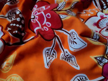 Çiçek, dal ve turuncu arka planlı yaprak motifli kumaşın deseni ve arkaplanı