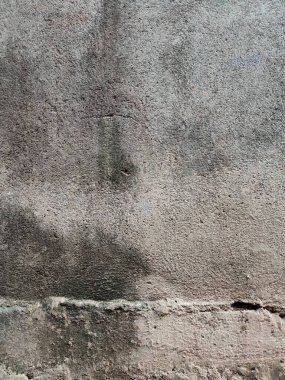 Duvarın arka planı ve dokusu kaba ve boyanmamış.