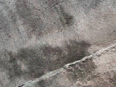 Duvarın arka planı ve dokusu kaba ve boyanmamış.