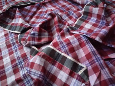 The pattern and background of the fabric is a checkered material in purple, red, brown and white.