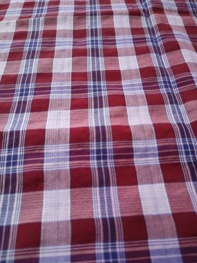 The pattern and background of the fabric is a checkered material in purple, red, brown and white.