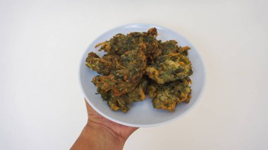 Beyaz arka planda yeşil salatalı kızarmış tavuk kanadı.