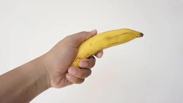 Beyaz arka plan üzerinde izole bir muz tutan el