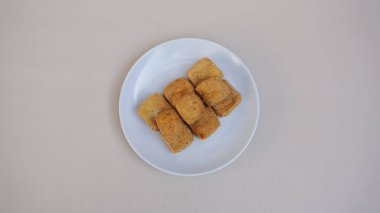 Beyaz bir arka plan üzerine bir tabak kızarmış tavuk