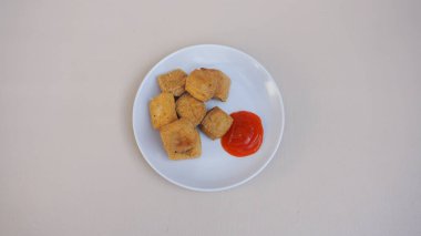 Kızarmış tavuk göğsü ve beyaz arka planda ketçap tabağı. yüksek kaliteli fotoğraf