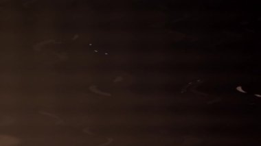 Parlak dalgalanan ışık ışınları karanlık bir arkaplanda.