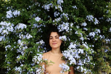 Parkta mavi çiçekli güzel bir kadının portresi.