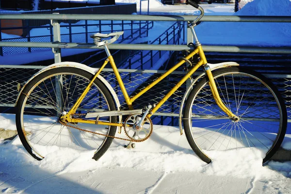 Parked bicycle in the snow in the station, closeup photo