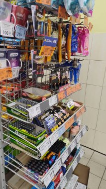 Dnipro, Ukrayna - 22 Mart 2025: Bataryalar, çakmaklar, kişisel bakım ürünleri de dahil olmak üzere süpermarket raflarında çeşitli kolaylık ürünleri. Perakende satış, alışveriş, mağaza organizasyonu. Dikey