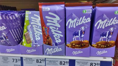 Dnipro, Ukrayna - 09 Nisan 2025: Süpermarket raflarında çeşitli sütlü çikolatalar. Tatlı hoşgörü, çikolata seçimi, market alışverişi.