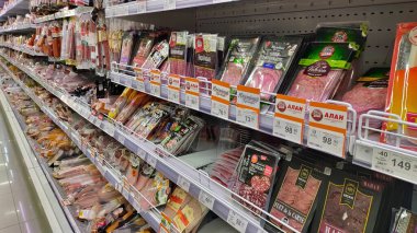 Dnipro, Ukrayna - 09 Nisan 2025: Süpermarket raflarında çeşitli paketlenmiş et çeşitleri. Gıda çeşitliliği, market alışverişi, yemek planlaması.