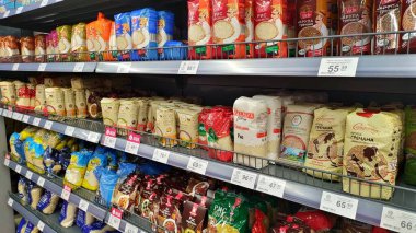 Dnipro, Ukrayna - 09 Nisan 2025: Süpermarket raflarında çeşitli pirinç paketleri. Market alışverişi konsepti, yiyecek seçimlerinde çeşitlilik, uluslararası mutfaklar.
