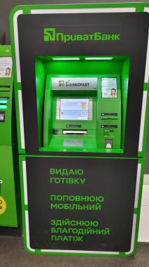 Dnipro, Ukrayna - 09 Nisan 2025: Modern banka ortamında neon aksanlı özel bankanın ATM 'sine yakın çekim. Finansal işlemler konsepti, fütüristik bankacılık, nakit çekilmesi. Dikey.