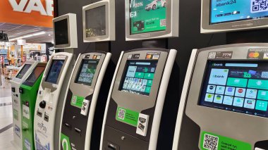 Dnipro, Ukrayna - 09 Nisan 2025: Alışveriş merkezinde dokunmatik ekranlı bankacılık ödeme terminalleri. Finansal hizmet kavramı, self servis teknolojisi, dijital işlem, perakende otomasyon.