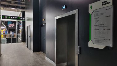 Dnipro, Ukrayna - 09 Nisan 2025: Günümüz alışveriş merkezindeki navigasyon işaretli ve zemin dizinli asansörler. Perakende satış merkezi kavramı, kapalı ulaşım, ticari navigasyon, müşteri hizmetleri.