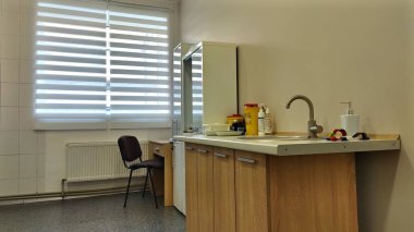 Ahşap dolapları ve güneşli pencereleri olan tıbbi bir ofis. Sağlık hizmetleri ortamı, profesyonel alan tasarımı, temiz tıbbi tesisler kavramı.