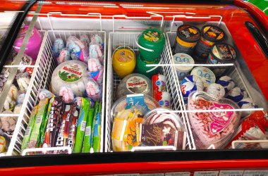 Dnipro, Ukrayna - 26 Nisan 2025 - marketteki dondurucuda çeşitli renkli dondurmalar ve dondurulmuş şekerler. Yaz içeceği, soğuk tatlılar, sıcak hava için tatlı ikramları.